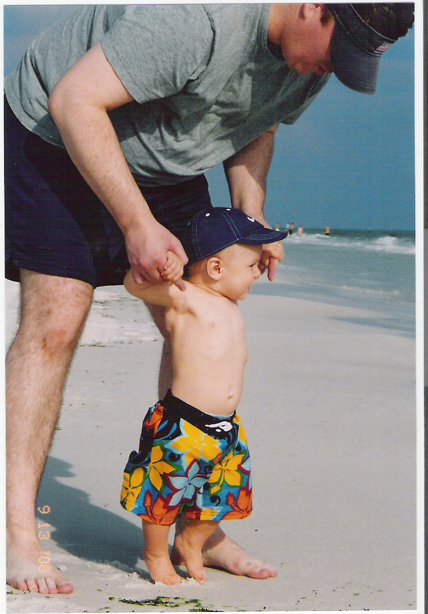 Baby Van walking on the beach with his dad